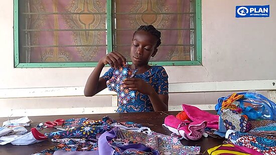 Ein Mädchen hält eine Menstruationsbinde aus Stoff in der Hand