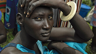 Die junge Frau Nyannyiir aus Südsudan wartet auf die Vergabe von Nahrungsmitteln