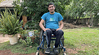 Ein junger Mann sitzt in einem Rollstuhl
