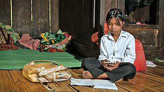 Ein junges Mädchen sitzt auf einer Matte
