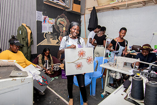 Faith und ihr Team in der Werkstatt neue Produkte verarbeitend