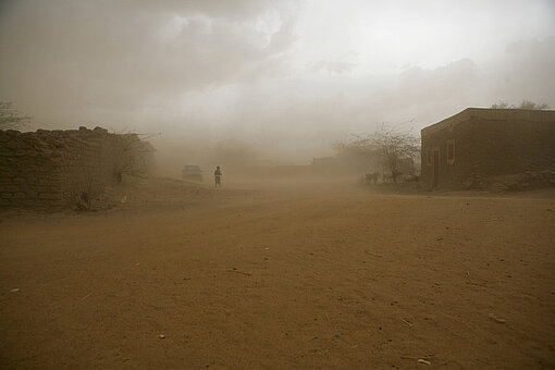 Sand wirbelt über ein nigrisches Dorf hinweg