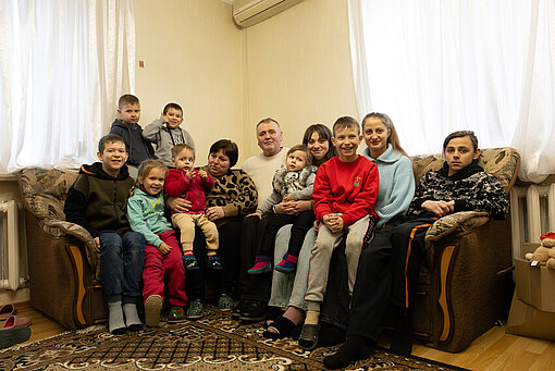 Yuri und Nadia mit all ihren Pflegekindern vereint auf dem Sofa
