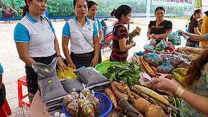 Agrarmesse in Vietnam: Frauen verkaufen regionale Produkte zur Stärkung ihrer wirtschaftlichen Position. Junge Frauen präsentieren und verkaufen selbst erzeugte landwirtschaftliche Produkte auf einer Messe in Vietnam.