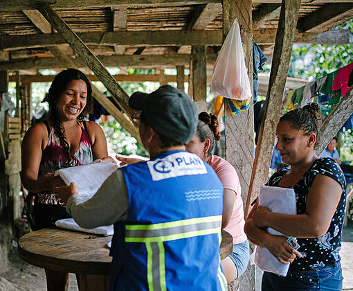 Mehrere Frauen nehmen an einem Workshop von Plan International zu Hygiene und Infektionsschutz während Hochwasser teil.