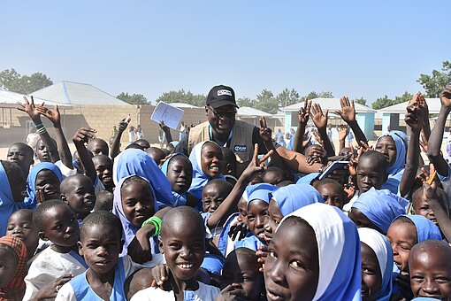 Plan-Länderdirektor Hussaini Abdu möchte, dass alle Kinder Schulbildung erhalten Gruppenfoto Kinder am Lachen