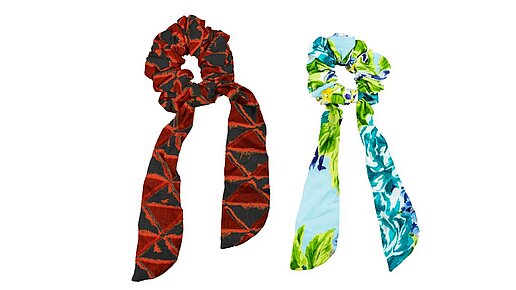 Scrunchies 2er Scrunchie Set. An dem mit Stoff ummantelten Gummi hängen zwei Schleifenenden.