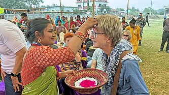 Eine Mitarbeiterin von Plan International freut sich über das große Interesse an ihrer Arbeit