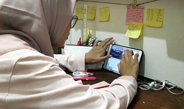 Eine junge Frau lernt den Umgang mit einem Tablet-Computer