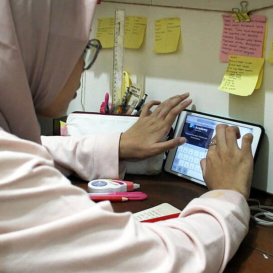 Eine junge Frau lernt den Umgang mit einem Tablet-Computer