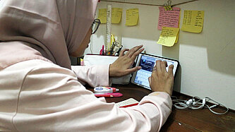 Eine junge Frau lernt den Umgang mit einem Tablet-Computer