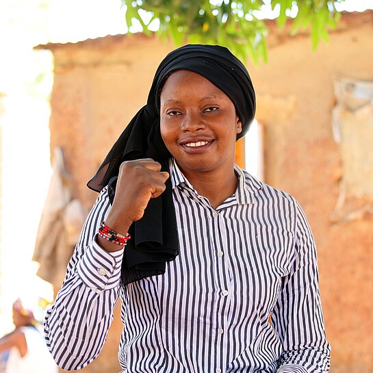 Adiara sitzt draußen in ihrer Gemeinde in Mali 