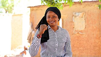 Adiara sitzt draußen in ihrer Gemeinde in Mali 