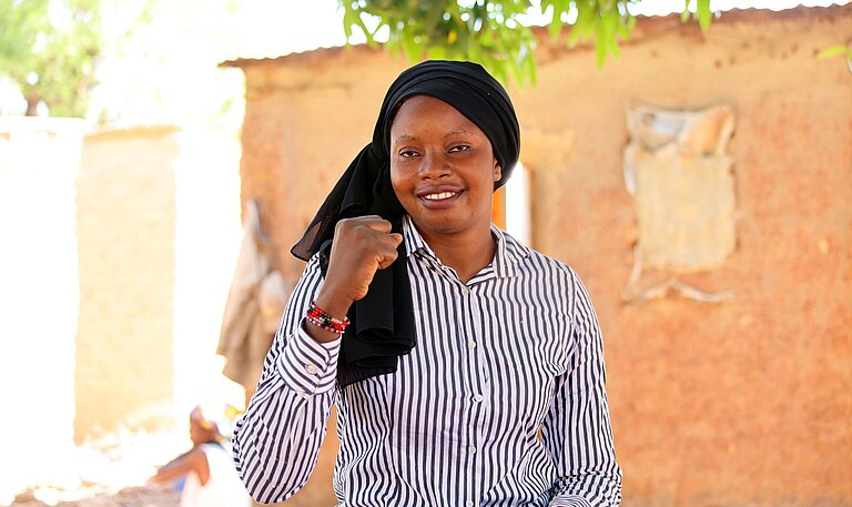 Adiara sitzt draußen in ihrer Gemeinde in Mali 