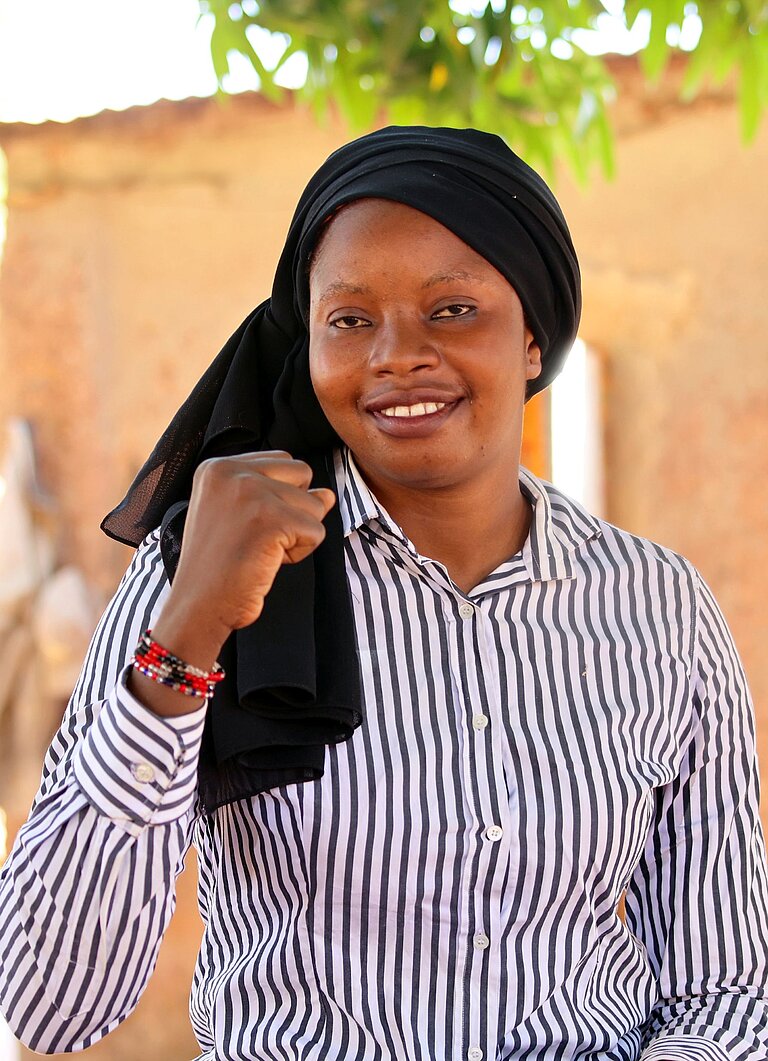 Adiara sitzt draußen in ihrer Gemeinde in Mali 