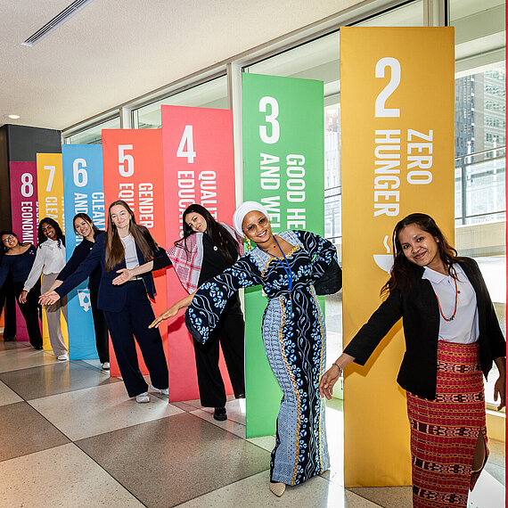 Jugenddelegierte verschiedener Kulturen präsentieren die 17 Nachhaltigkeitsziele (SDGs) bei der 69. Sitzung der Frauenrechtskommission (CSW69) 2025 im Hauptquartier der Vereinten Nationen in New York. Die jungen Frauen setzen sich für Gleichstellung und die Stärkung weiblicher Führung ein.