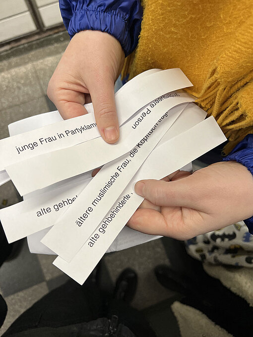 Eine Person hält viele Papierschnipsel in der Hand.