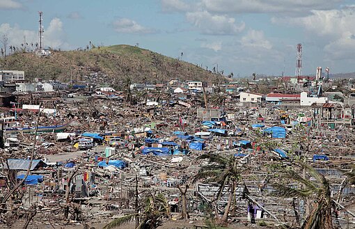 Ein Motiv, das um die Welt ging: Super-Taifun Haiyan hinterließ 2013 auf den Philippinen eine Schneise der Verwüstung Der Blick geht auf eine Hügelkette, auf der von ehemaligen Wohnhäusern nur noch Trümmer zu sehen sind