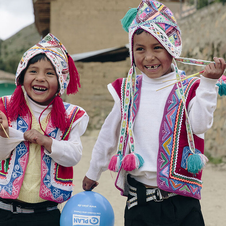 Zwei Kinder in traditioneller peruanischer Kleidung.