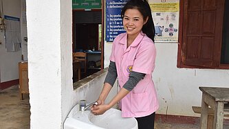 Midwife Somboun, 23, washes her hands at the Plan-supported heal