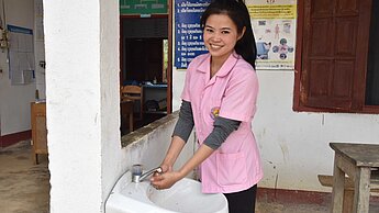 Midwife Somboun, 23, washes her hands at the Plan-supported heal