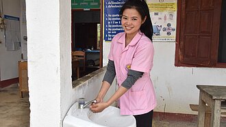 Midwife Somboun, 23, washes her hands at the Plan-supported heal