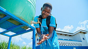 Mädchen wäscht Hände vor den neu gebauten Mädchentoiletten.