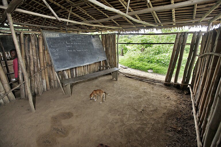Ein leeres Klassenzimmer mit einer Tafel, ohne Tische und Stühle.