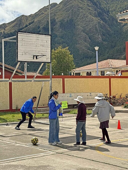 Kinder sspielen Basketball auf einem Sportplatz mitten zwischen den Bergern.