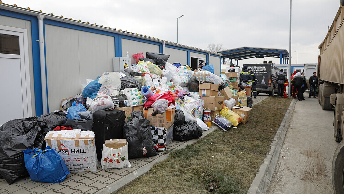 Ein riesiger Berg voller Hilfsgüter liegt vor einem Gebäude