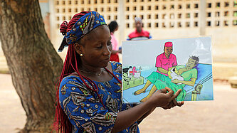 Junge Frau zeigt eine Zeichnung einer postnatalen Untersuchung