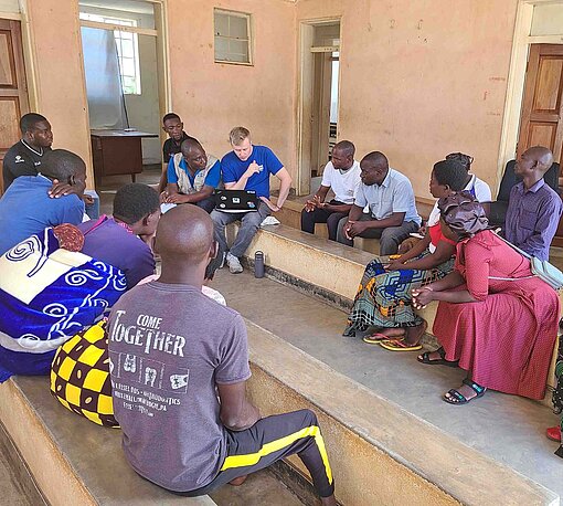 Eine Gruppe Frauen und Männer sitzt zusammen in einem Besprechungsraum