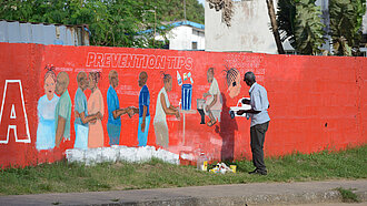 Ebola-Krise 2014: Ein Künstler animiert mit einem Wandbild in der liberischen Hauptstadt Monrovia zum Schutz vor Ansteckung durch Händewaschen. Plan International arbeitete seinerzeit bereits entlang des globalen Risikomanagement-Systems. ©Neil Brandvold