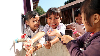 Dank einer neuen Handwaschanlage können Souda und ihre Freunde aus Laos jederzeit ihre Hände waschen. © Plan International