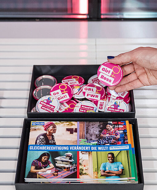 Eine Aufnahme von Prospekten und Anstecknadeln zum Thema Mädchen-Rechte