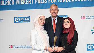 Ulrich Wickert mit Batoul (links) und Awaz (rechts), die stellvertretend für die "Youth Advocates" den Sonderpreis in Empfang genommen haben. © Plan International/Michael Fahrig