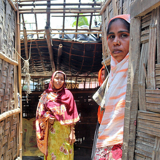 Zwei Frauen stehen in ihrem zerstörten Haus in Bangladesch