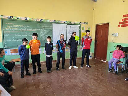 Kinder blasen Luftballons in einem Klassenraum auf