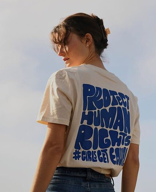 Eine Frau trägt ein T-Shirt auf dessen Rücken Protect Human Rights steht
