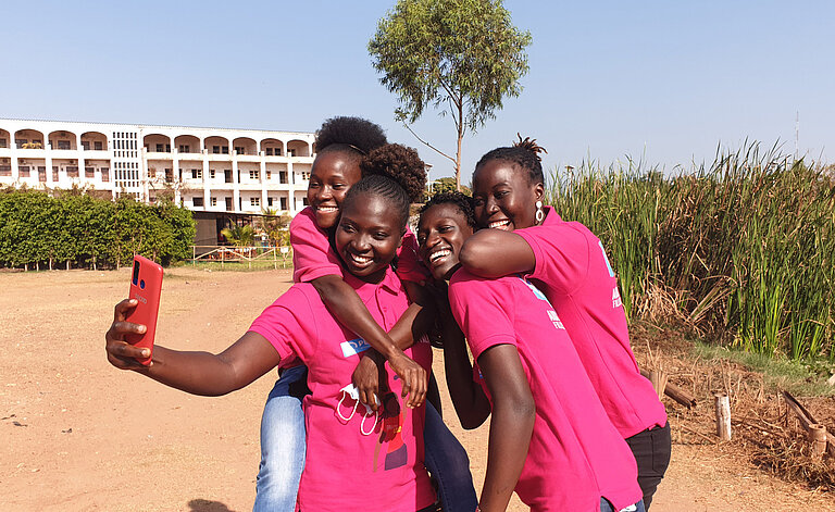 Vier Mädchen in pinken Tshirts machen ein Selfie.