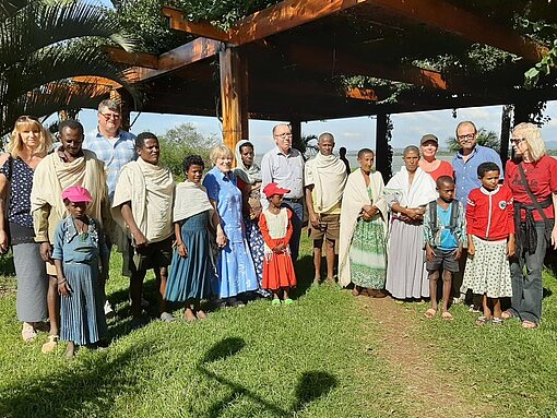 Pat:innen und Kinder stehen unter Holz-Pavillion.