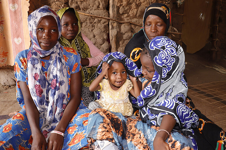 Safina mit ihren drei etwas älteren Töchtern und ihrer 18 Monate alten Tochter, sie sitzen gemeinsam auf dem Boden