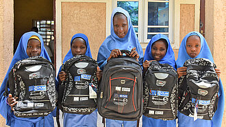 Mädchen haben Rucksäcke für den Schulbesuch erhalten