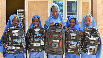 Mädchen haben Rucksäcke für den Schulbesuch erhalten