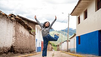 Ein jugendliches Mädchen aus Peru springt in die Luft