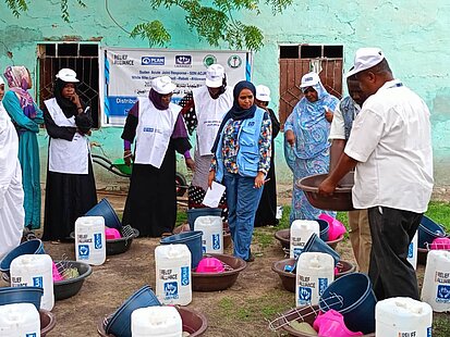Frauen erhalten Nahrungsmittel von einem Helfer
