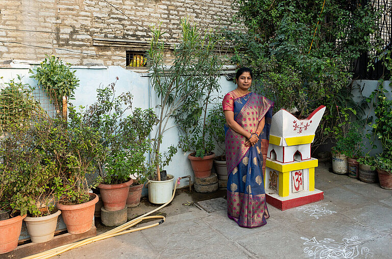 Eine Frau im Sari steht in einem Innenhof in Indien