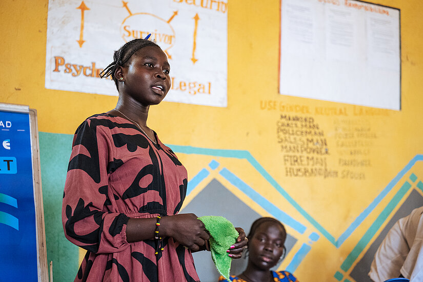 Young woman in Ethiopia speaks confidently during a gender equality workshop in a classroom setting.