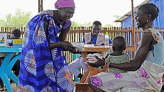 Die freiwillige Plan-Gemeindehelferin Ngachower Etcho (56) verteilt Zusatznahrung. © Plan International