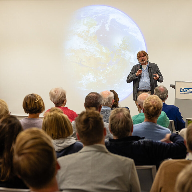 Arved Fuchs hält bei einer Veranstaltung der Stiftung Hilfe mit Plan einen Vortrag zum Klimawandel.
